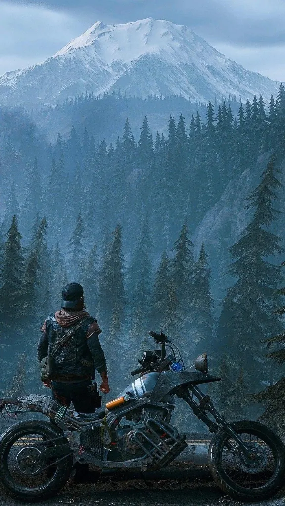 A rider and his motorcycle facing a snow-capped mountain