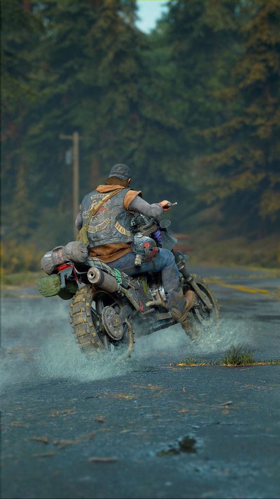 A rider splashing through a puddle on a forest highway